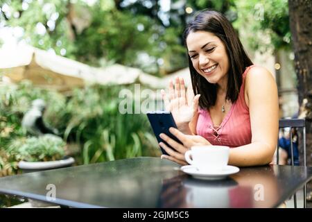 Young woman using mobile phone and talking with friends through video call Stock Photo