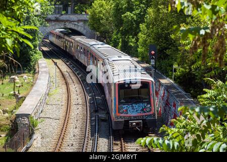 Subway train in Athens, Greece, Europe. Railroad cars painted with graffiti on street, metro road in Athens city center outdoors in summer. Concept of Stock Photo