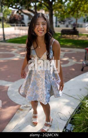 Teenage Asian Girl Walking Around Park in Sweet 16 Dress Stock Photo