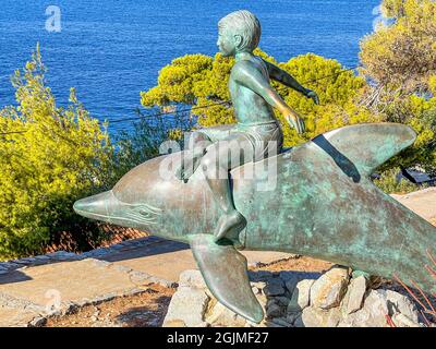 Beautiful statue of a bronze Boy on a Dolphin, an artwork based on the film of the same name, filmed here in 1957, Hydra Island, Greece Stock Photo