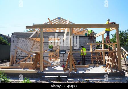 Roofers Building Wood Trusses Roof Frame House Construction. Roofing construction with wooden beams frame and terrace roof truss. Stock Photo