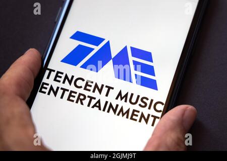 Tencent Holdings Ltd. is a Chinese multinational technology conglomerate holding company. A smartphone with the Tencent music entertainment logo Stock Photo