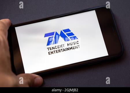 Tencent Holdings Ltd. is a Chinese multinational technology conglomerate holding company. A smartphone with the Tencent music entertainment logo Stock Photo