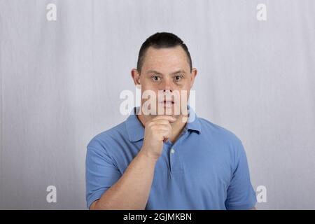 Cool Hispanic guy with Down syndrome posing wearing a blue polo shirt Stock Photo