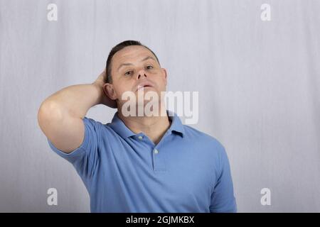 Cool Hispanic guy with Down syndrome posing wearing a blue polo shirt Stock Photo