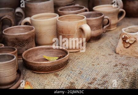 Traditional Ceramic Jugs on Decorative Towel. Showcase of Handmade Ceramic Pottery in a Roadside Market with Ceramic Pots and Clay Plates. Stock Photo