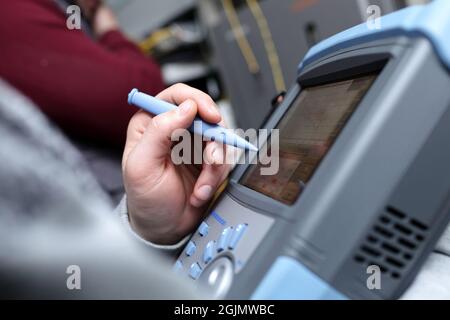 The technician holding a telecom analyzer at site Stock Photo