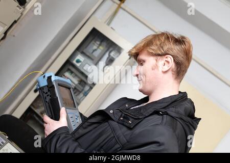 The maintenance technician holding reflectometer in a telecom site Stock Photo