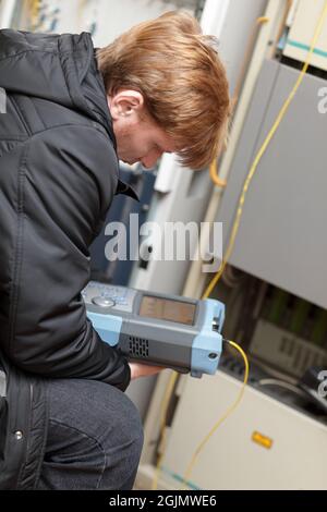 The maintenance engineer holding fibre optic analyzer at a telecom site Stock Photo