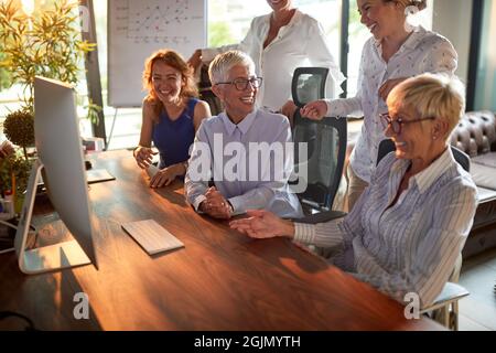 Group of business woman is enjoying working together in a friendly atmosphere at workplace. Business, office, job Stock Photo