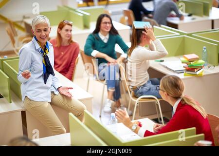 Female professor and students having good time at the lecture in a classroom Stock Photo