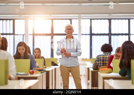 Female professor and students at the lecture in the classroom Stock Photo