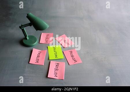 Business solutions, problem solving and brainstorming concept. Desk lamp, red paper with text PROBLEM and green paper with text SOLUTION Stock Photo