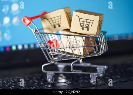 Shopping cart on notebook keyboard, online business import export concept. Stock Photo