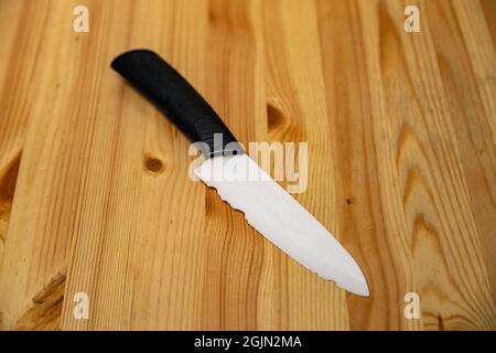close up old white ceramic knife with a chipped blade. broken substandard knife Stock Photo