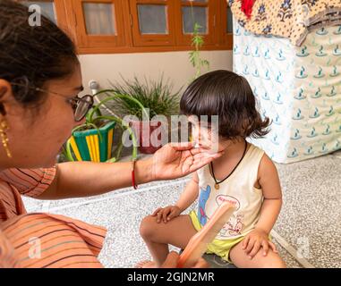 portrait of cute indian baby girl during haircut. Stock Photo