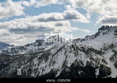 Winter landscape in the Italian Dolomites with snow-covered forests and ski slopes in the evening light Stock Photo