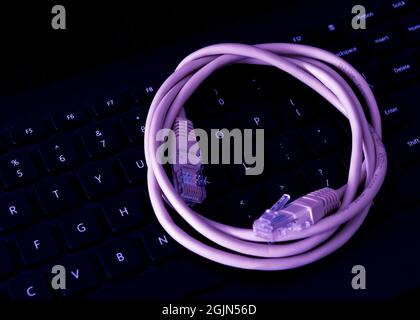 Network Cable resting on a computer keyboard Stock Photo
