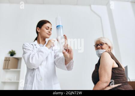 emotional elderly woman hand injection hospital Stock Photo