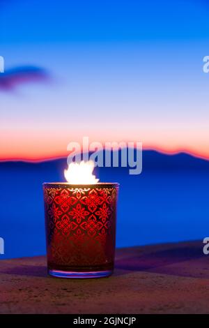 Beautiful candle glass at sunset in Italy with sea and Elba island in the background Stock Photo