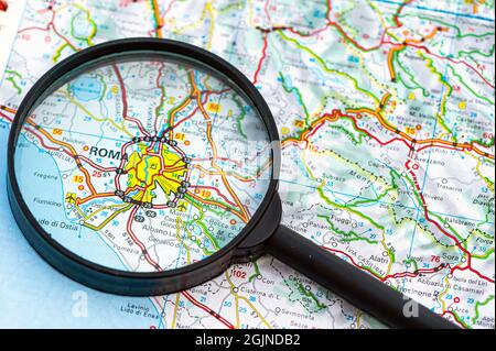 map of Rome in Italy through magnifying glass, concept of planning the travel itinerary Stock Photo