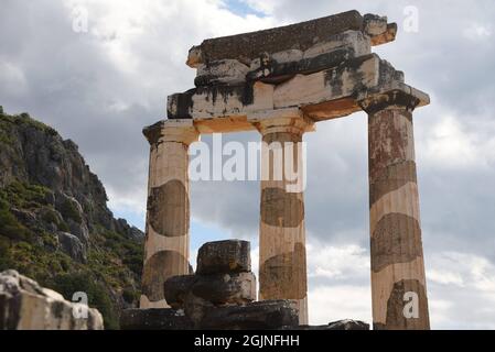 Ancient Doric order columns with the pediment, triglyph and metope at the sanctuary of Athena Pronaia the sacred archaeological site of Delphi Greece. Stock Photo