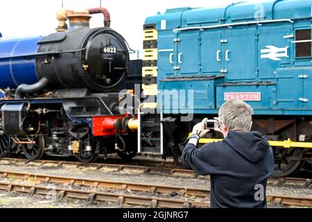 Didcot, Oxfordshire, England - June 2021: Person taking a picture of a steam engine at the Didcot Railway Centre. Stock Photo