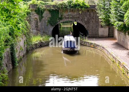 Bath, England - August 2021: Person steering a narrow boat along the Kennet and Avon canal near Bath city centre Stock Photo