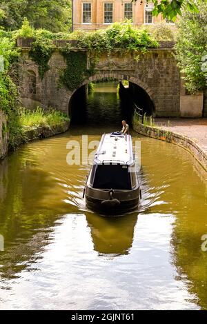 Bath, England - August 2021: Person steering a narrow boat along the Kennet and Avon canal near Bath city centre Stock Photo