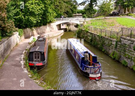 Bath, England - August 2021: Person steering a narrow boat along the Kennet and Avon canal near Bath city centre Stock Photo