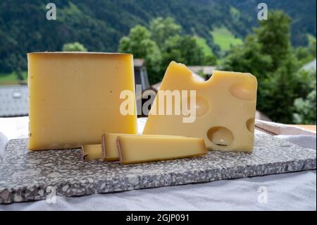 Cheese collection, Swiss cow cheese emmental and gruyere and mountains village in Apls in summer 2on background Stock Photo