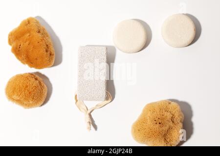 Yellow Natural bath or cleaning three sea sponges, dray shampoo, exfoliating body strap and pumice stone with strap on white background Stock Photo