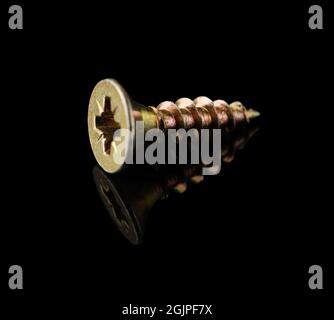 Wood screw yellow on a black background with reflection Stock Photo