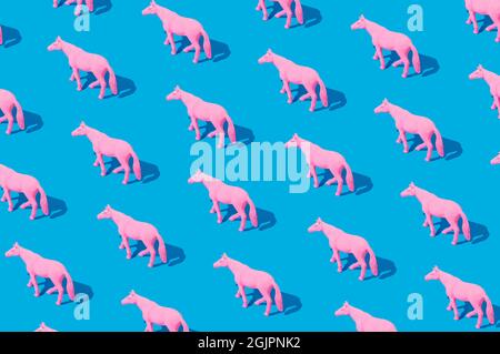 Collage of pink rubber horses isolated on blue background. Isometric rectangle layout. Minimal abstract concept Stock Photo