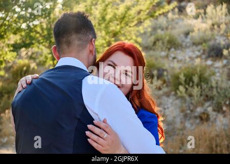 Woman hugs her beloved man looking to a camera Stock Photo