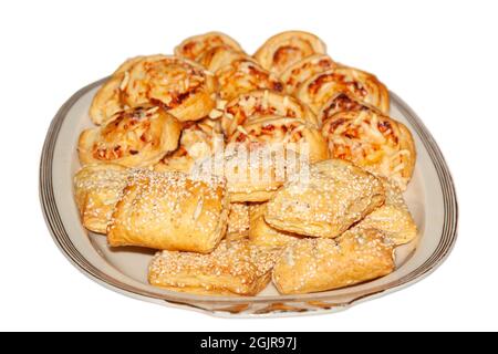 Puff pastries with cheese from the oven in a white plate, isolated on a white background Stock Photo