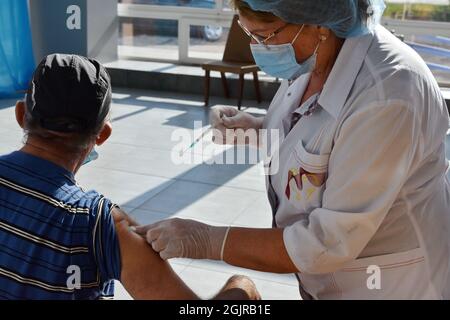 Kramatorsk, Ukraine. 11th Sep, 2021. A medical worker administers a Covid-19 vaccine to a man at a vaccination center inside the city's bus station in Kramatorsk.From September 13, a yellow level of epidemic threat may be introduced across Ukraine due to the growing COVID-19 incidence. This was stated by Health Minister Viktor Liashko. As for the red quarantine zone, it will be introduced in several regions, where the rates of morbidity and hospitalization exceed the normal ones. Credit: SOPA Images Limited/Alamy Live News Stock Photo