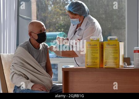 Kramatorsk, Ukraine. 11th Sep, 2021. A medical worker administers a Covid-19 vaccine to a man at a vaccination center inside the city's bus station in Kramatorsk.From September 13, a yellow level of epidemic threat may be introduced across Ukraine due to the growing COVID-19 incidence. This was stated by Health Minister Viktor Liashko. As for the red quarantine zone, it will be introduced in several regions, where the rates of morbidity and hospitalization exceed the normal ones. Credit: SOPA Images Limited/Alamy Live News Stock Photo