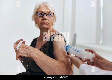 emotional elderly woman syringe injection vaccine passport Stock Photo