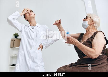 emotional elderly woman syringe injection immunity protection Stock Photo