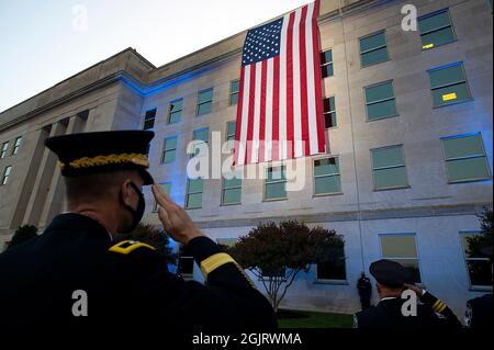 Officers salute an American flag unfurled over the side of the Pentagon at sunrise on the 20th anniversary of the 9/11 terrorist attacks at the Pentagon September 11, 2021 in Arlington, Virginia. Mandatory Credit: EJ Hersom/DoD via CNP/MediaPunch Stock Photo