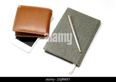 Notebook with pen smartphone and brown leather wallet isolated on white background Stock Photo