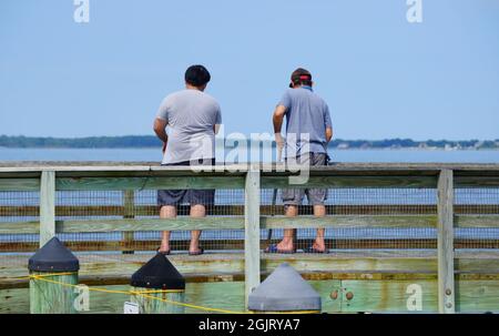 Two guys crabbing on Romancoke fishing pier in the hot summer day near Kent Island, Maryland, U.S Stock Photo