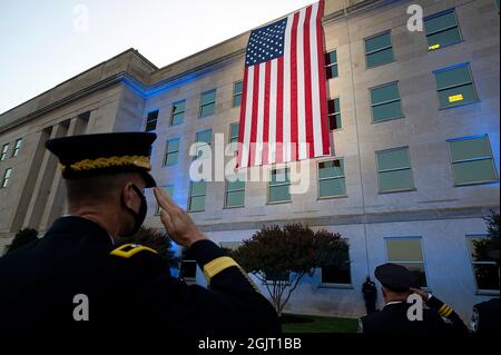 Arlington, Virginia. 11th Sep, 2021. Officers salute an American flag unfurled over the side of the Pentagon at sunrise on the 20th anniversary of the 9/11 terrorist attacks at the Pentagon September 11, 2021 in Arlington, Virginia. Mandatory Credit: EJ Hersom/DoD via CNP/dpa/Alamy Live News Stock Photo