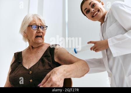 emotional elderly woman big syringe hospital Stock Photo