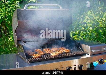 Hamburgers filling up the racks in a backyard barbecue on a beautiful ...