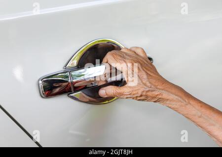 Elderly woman open the car door Stock Photo