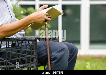 Senior male sitting and relax in backyard Stock Photo