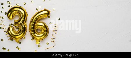 golden foil balloon number thirty six. Birthday or anniversary card with the inscription 36. gray concrete background. Anniversary celebration. Banner Stock Photo