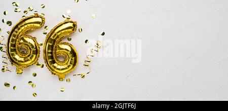 golden foil balloon number sixty six. Birthday or anniversary card with the inscription 66. gray concrete background. Anniversary celebration. Banner. Stock Photo